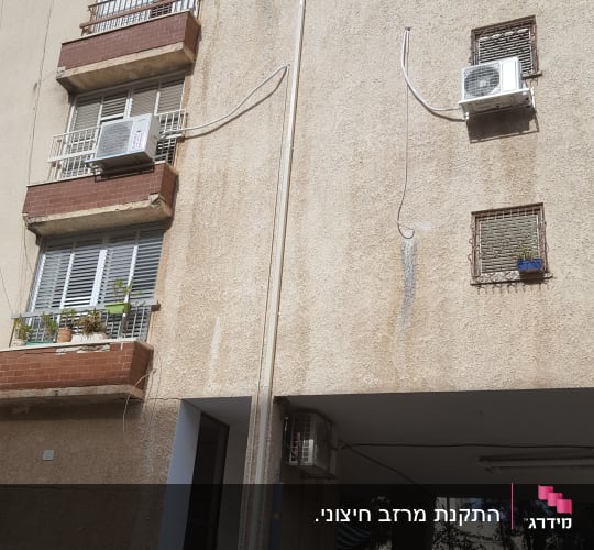 בניין עם מרפסות ומזגנים על הקיר החיצוני